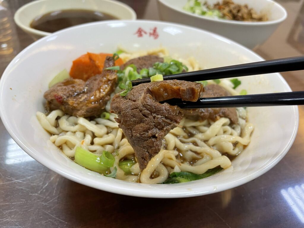 高雄 牛肉麵の牛肉を箸で持ち上げた様子。金湯麵食館の看板メニューで柔らかい