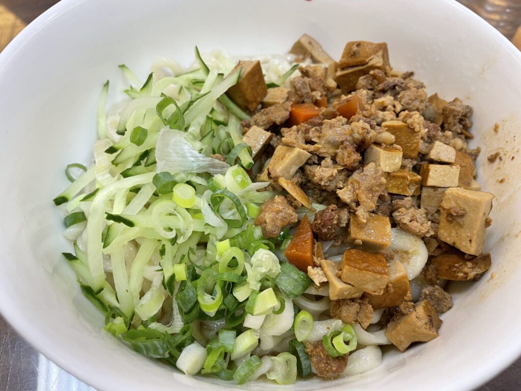 高雄 牛肉麵の名店「金湯麵食館」のジャージャー麺。刻んだきゅうり(cucumber)、青ねぎ、豆腐(tofu)、carrotの角切り、肉そぼろがのった一品