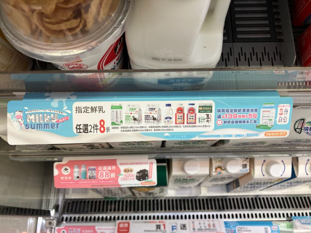 台湾のコンビニの冷蔵ケースに表示される複数の割引キャンペーン「MILKY summer」「指定鮮乳（designated fresh milk）」「任選2件8折」などのバナー