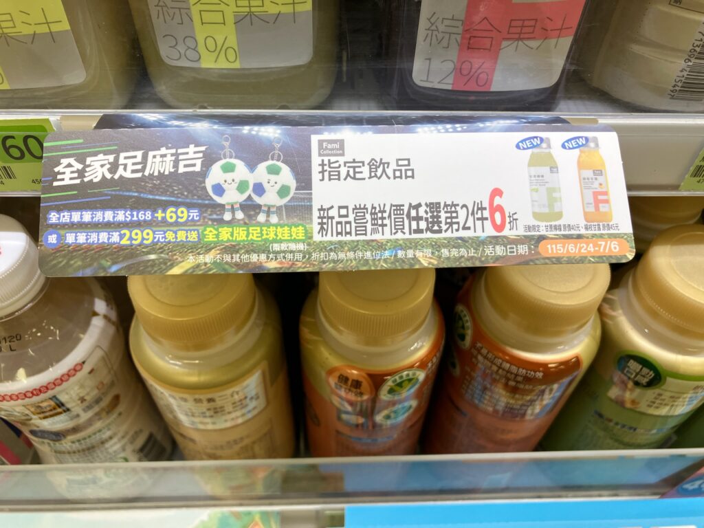 台湾のコンビニの棚に表示される複数のキャンペーンバナー「全家足麻吉」「Fami Collection」「指定飲品・新品嚐鮮買任選第2件6折」