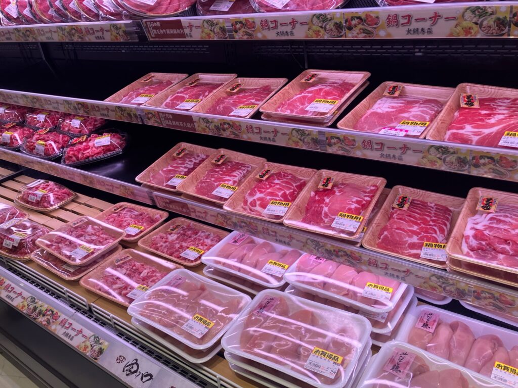 ロピアの豚肉売り場。「鍋コーナー（火鍋寿区）」の看板のもと、鍋物用の豚肉スライスや炒め用肉が多数並ぶ。