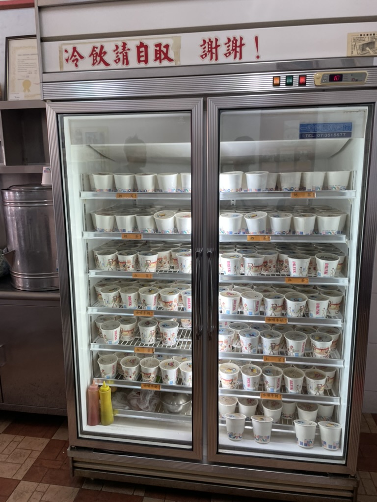 楠梓 小籠包の食堂内にある冷蔵庫、セルフサービスの冷たい飲み物カップがずらりと並ぶ様子