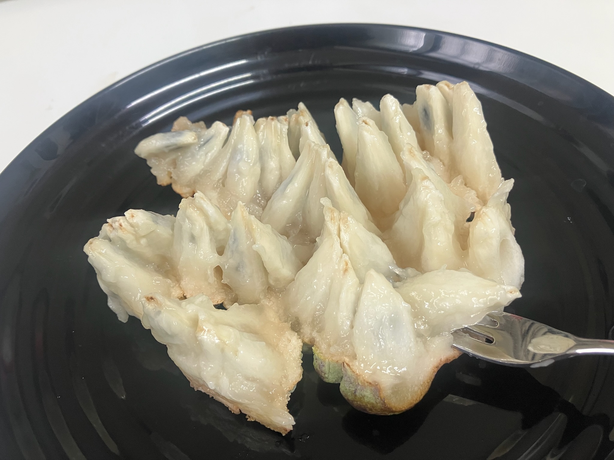 フォークで一粒ずつ取り分けた釈迦頭の白い果肉のアップ。釈迦頭の食べ方を工夫した盛り付け