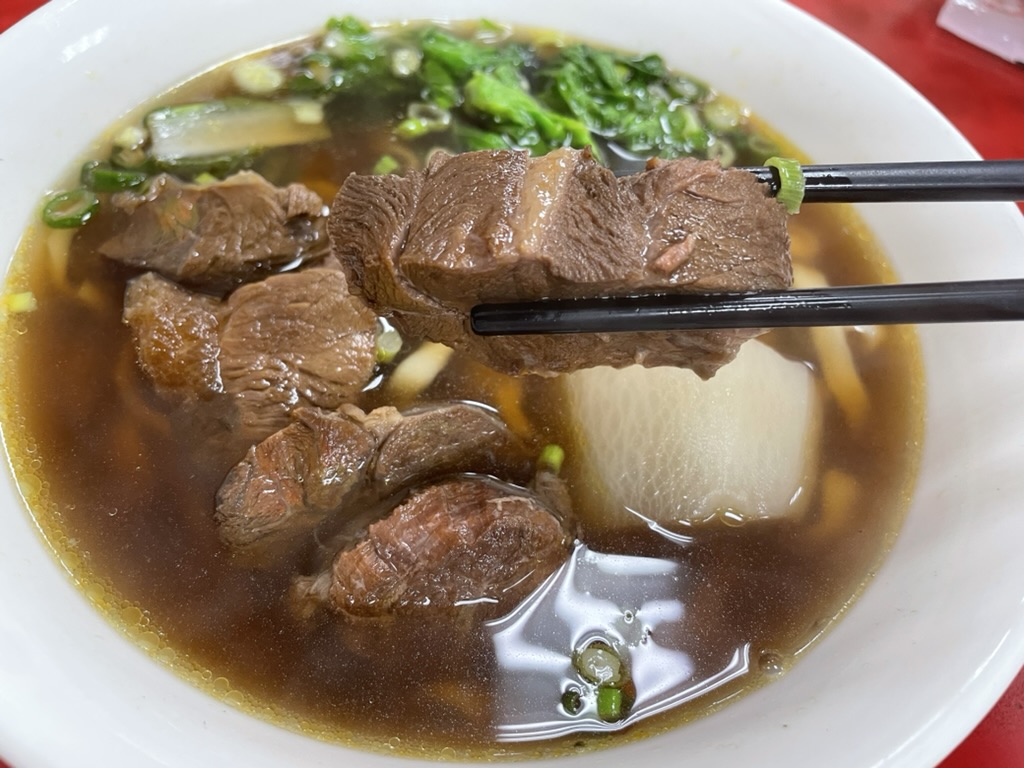高雄 小籠包の名店で味わう牛肉麵の牛肉塊。箸でつまむとほろほろと崩れるほど柔らかく煮込まれている