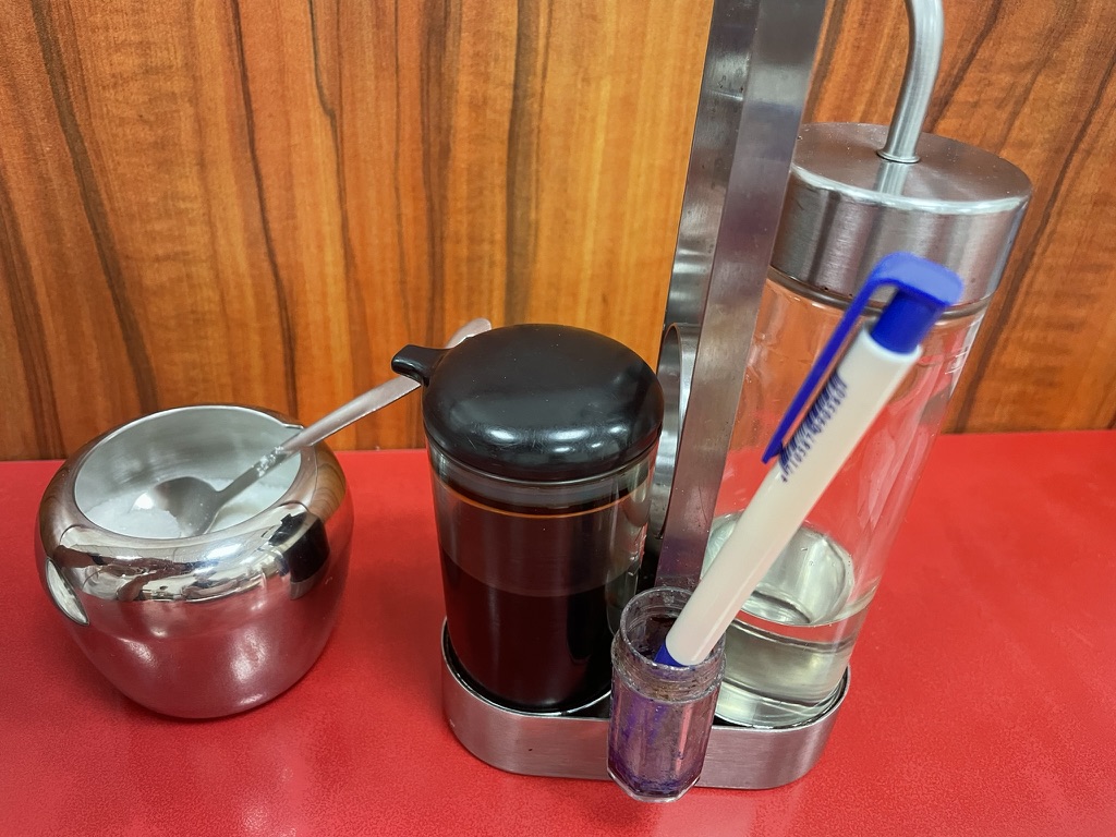 高雄 小籠包の名店で卓上に並ぶ調味料、醤油とお酢（白醋）、砂糖入れとスプーン