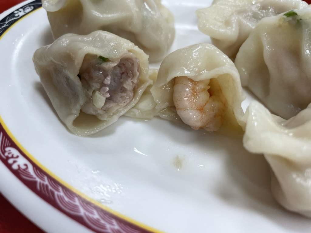 高雄 小籠包の名店で食べた鮮蝦韭黃水餃（xian xia jiu huang shui jiao）の断面、大振りのむき海老とニラ餡がゴロッと入っています