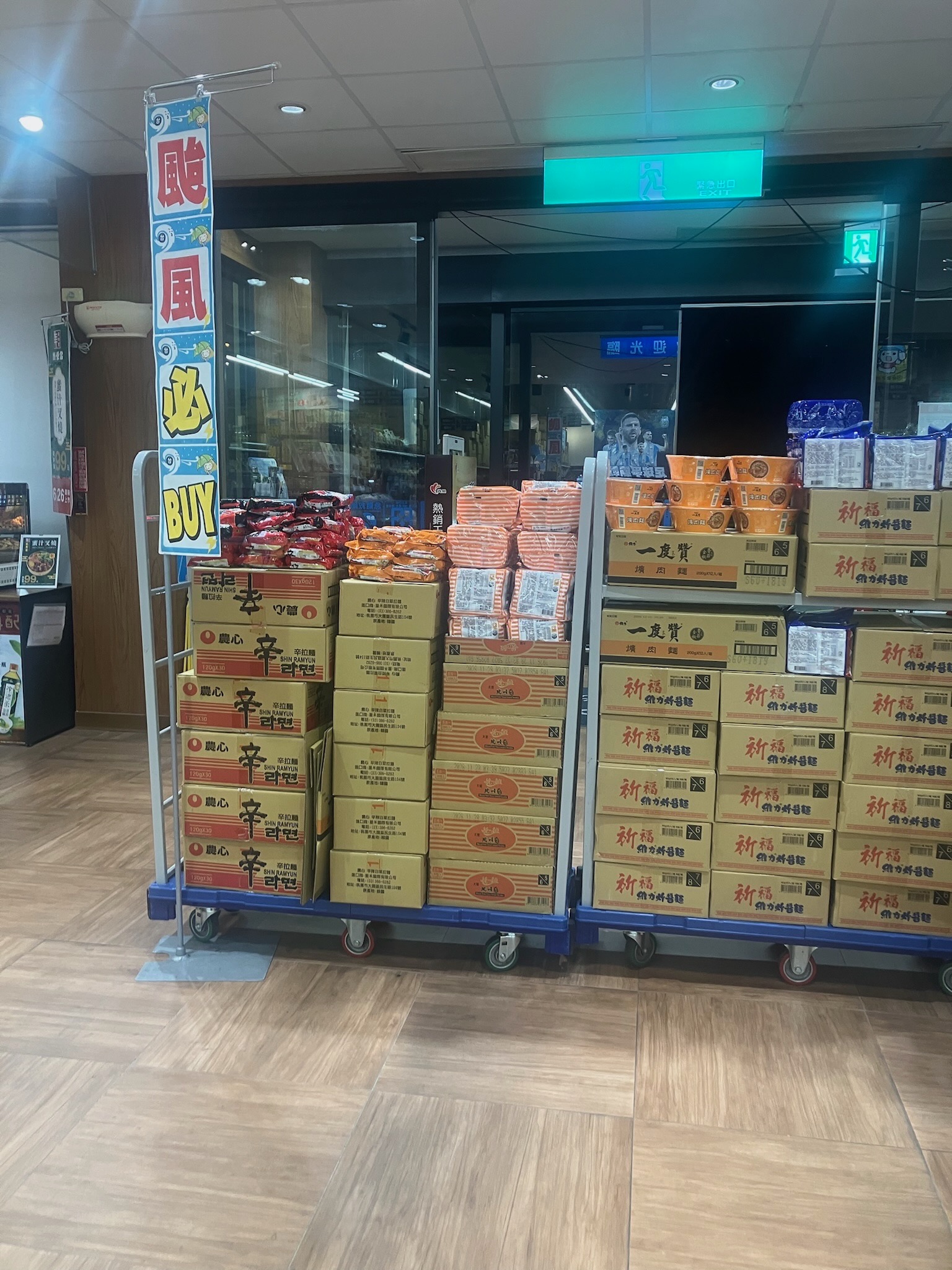 台湾のスーパーに山積みされたカップ麺と「颱風必BUY」の垂れ幕、停班停課前の買い出し風景
